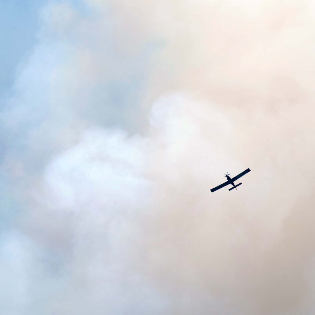 Airplane emerging from a cloud of smoke